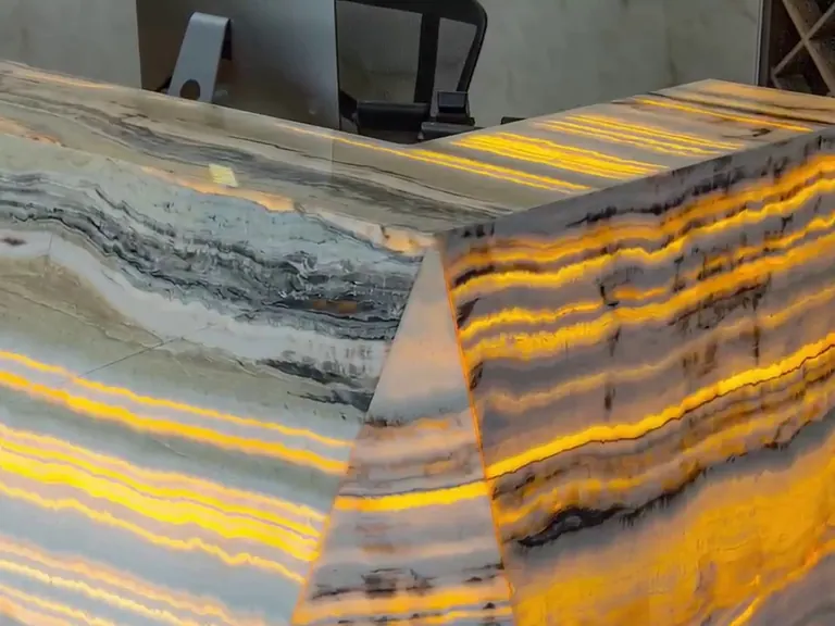 Corner of an illuminated stone reception desk.