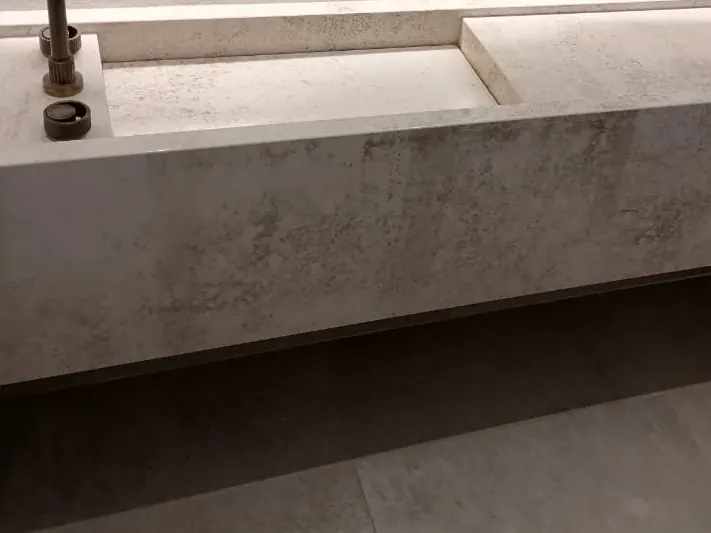Stone vanity top, basin opening and brass tap.