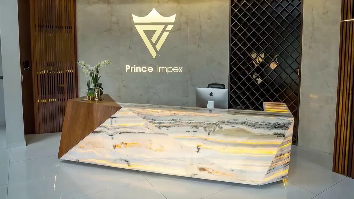 Illuminated stone reception desk in an office interior.