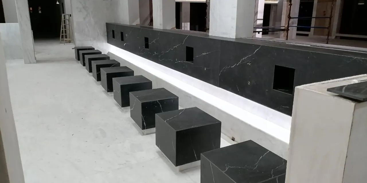 Black stone seating blocks beside a lit stone counter in an interior under construction.