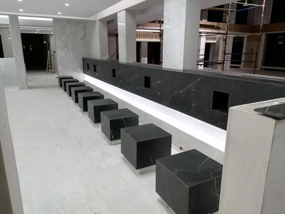 Black stone seating blocks beside a lit stone counter in an interior under construction.