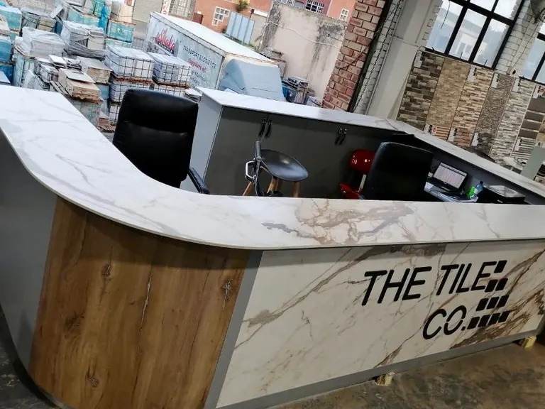 Reception counter with stone-clad front and lettering.